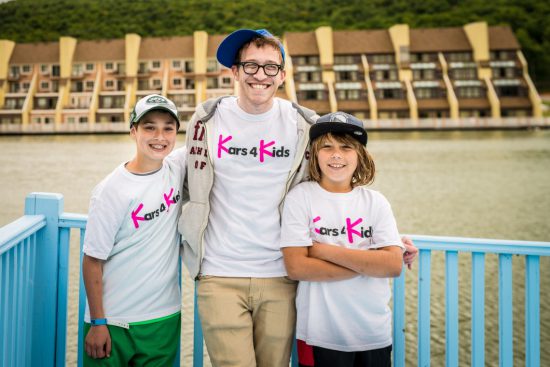 A camp instructor and 2 children wearing kars4kids t shirts